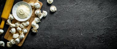 Ekşi krema ile çiğ köfte. Siyah rustik arka plan üzerinde