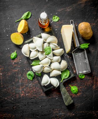 Patates, Parmesan ve ıspanak ile çiğ köfte. Koyu rustik arka plan üzerinde