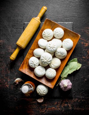 Taze hazırlık ham manta köfte ile oklava. Koyu rustik arka plan üzerinde