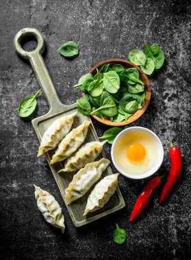 Biber, yumurta ve ıspanak ile çiğ gedza köfte. Koyu rustik arka plan üzerinde