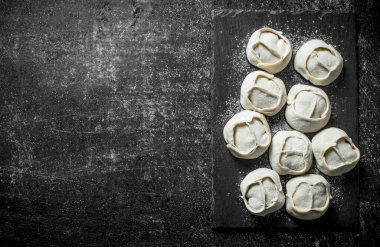 Çiğ manta köfte sığır eti ile. Koyu rustik arka plan üzerinde