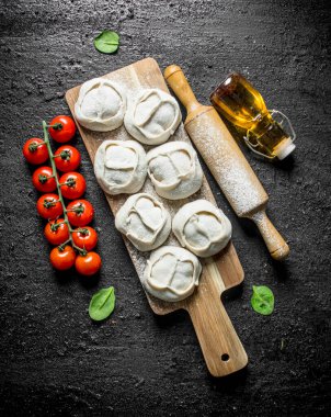 Kesme Tahtası üzerinde et ile çiğ manta köfte. Siyah rustik arka plan üzerinde