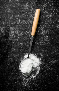 Un kepçesi. Siyah rustik arka plan üzerinde