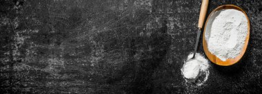 Kasede un ve kepçe. Siyah rustik arka plan üzerinde