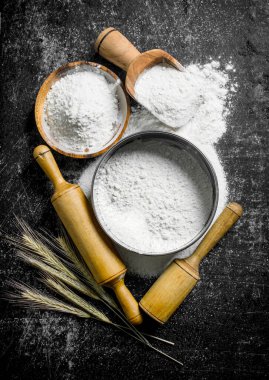 Çivi, elek ve oklava ile un. Koyu rustik arka plan üzerinde