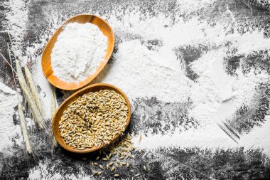 Sivri uçlu kaselerde un ve buğday tanesi. Rustik arka planda