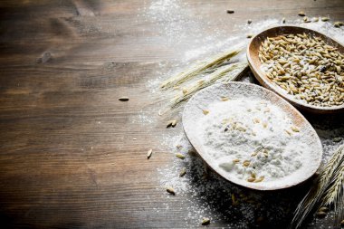 Kaselerde tahıl ile un. Ahşap arka planda