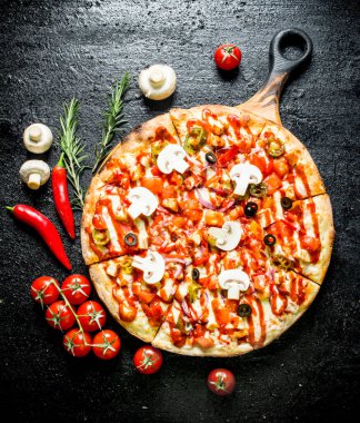 Acı biber, domates ve mantar ile Pizza. Siyah rustik arka plan üzerinde