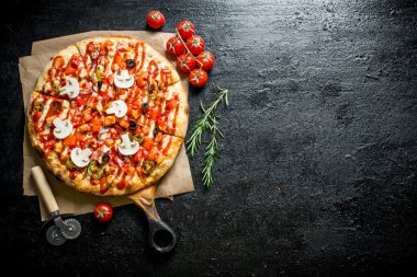 Domates li ve biberiyeli kokulu pizza. Siyah rustik arka plan üzerinde