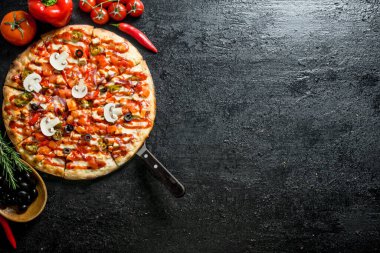 Zeytin, sosis ve domatesli pizza. Siyah rustik arka plan üzerinde