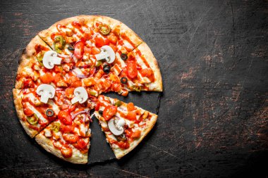 Domates, biber ve mantar ile gevrek pizza dilimleri. Koyu rustik arka plan üzerinde