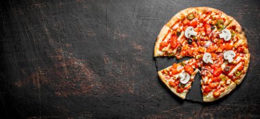 Domates, biber ve mantar ile gevrek pizza dilimleri. Koyu rustik arka plan üzerinde