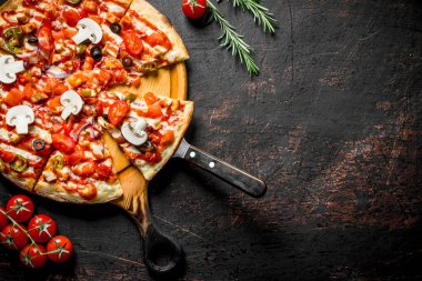 Kesme Tahtasında dilimlenmiş kokulu Meksika pizzası. Koyu rustik arka plan üzerinde