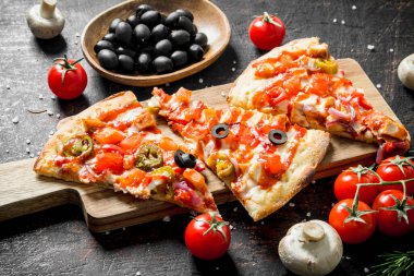 Zeytin, domates ve mantar ile kokulu pizza dilimleri. Koyu rustik arka plan üzerinde