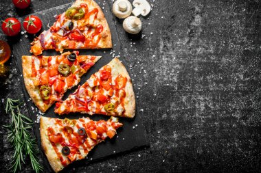 Salam lı ve domatesli Meksika pizzası dilimleri. Koyu rustik arka plan üzerinde