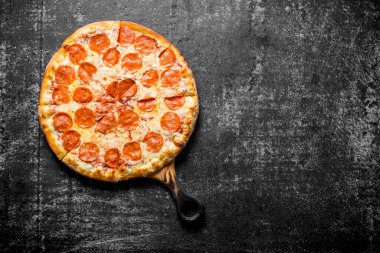 Kesme Tahtasında kokulu pepperoni pizza. Koyu rustik arka plan üzerinde