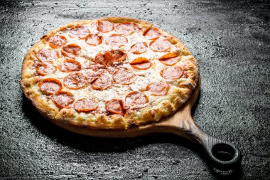 Taze pişmiş pepperoni pizza. Siyah rustik arka plan üzerinde