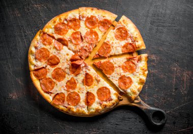 Kesme Tahtasında gevrek biberli pizza. Koyu rustik arka plan üzerinde