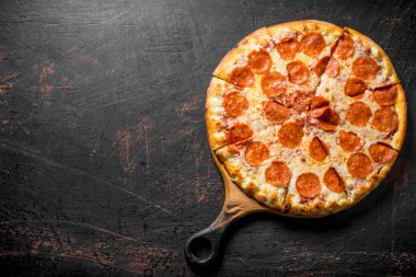Kesme Tahtasında gevrek biberli pizza. Koyu rustik arka plan üzerinde