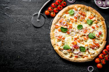 Dalda domatesli pizza. Siyah rustik arka plan üzerinde