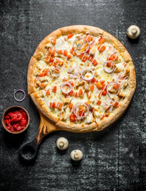 Tavuk ve peynir soslu pizza. Koyu rustik arka plan üzerinde