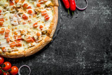 Tavuk ve peynir soslu pizza. Koyu rustik arka plan üzerinde