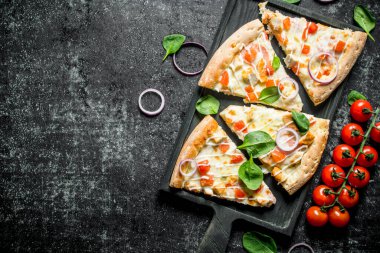 Taze pişmiş tavukpizza dilimleri. Koyu rustik arka plan üzerinde