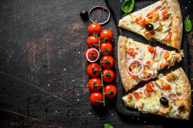 Kesme Tahtasında kokulu pizza dilimleri. Koyu rustik arka plan üzerinde