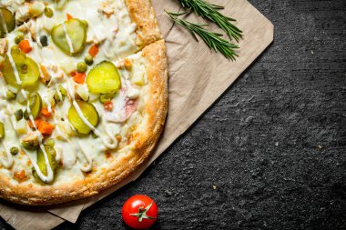 Biberiyeli kağıt üzerinde sebzeli pizza. Rustik arka planda