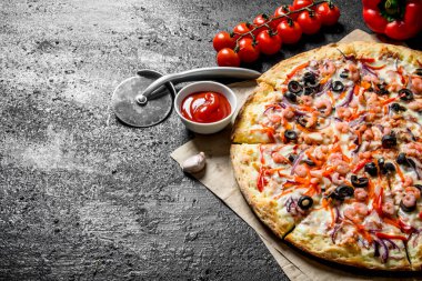Deniz ürünleri ve kiraz domatesli pizza. Siyah rustik arka plan üzerinde