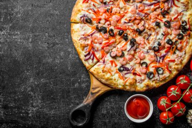 Karides ve peynir soslu deniz pizzası. Koyu rustik arka plan üzerinde