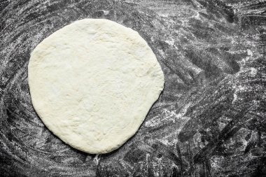 Pizza hamuru yuvarlanmış. Rustik arka planda