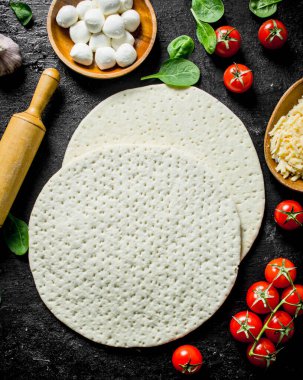 Hazır pizza. Domates, peynir ve ıspanak ile yuvarlak hamur. Siyah rustik arka plan üzerinde