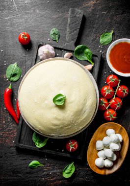 Taze ev yapımı pizza hazırlanması. Koyu rustik arka plan üzerinde