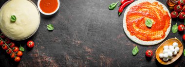 Ev yapımı pizza için farklı malzemelerle hamur. Koyu rustik arka plan üzerinde