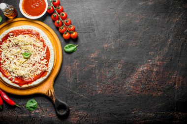 Çiğ pizza. Ev yapımı pizza için hamur yuvarlanmış. Koyu rustik arka plan üzerinde