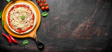 Çiğ pizza. Ev yapımı pizza için hamur yuvarlanmış. Koyu rustik arka plan üzerinde