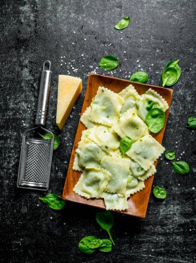 Parmesan ve ıspanaklı ravioli. Koyu rustik arka plan üzerinde