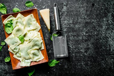 Parmesan ve ıspanaklı ravioli. Koyu rustik arka plan üzerinde