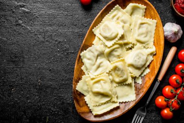 Sığır eti ve domatesli ravioli. Siyah rustik arka plan üzerinde