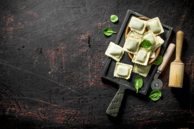 Ham Ravioli bir kesme Tahtası üzerinde dana eti ile. Koyu rustik arka plan üzerinde