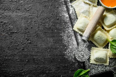 Ravioli çiğ bir kesme Tahtası üzerinde et ile. Siyah rustik arka plan üzerinde