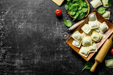 Parmesan peyniri ve otlar ile Ham Ravioli. Koyu rustik arka plan üzerinde