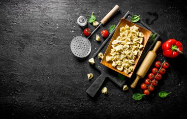 Domates, tatlı biber ve ıspanak ile çiğ Köfte. Siyah rustik arka plan üzerinde