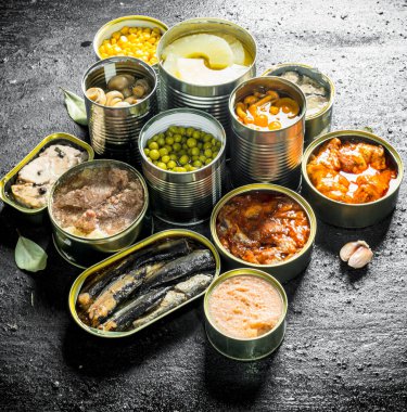 Konservelerde farklı türde konserve ler. Siyah rustik arka plan üzerinde