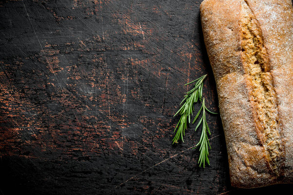 Bread ciabatta with rosemary. On dark rustic background