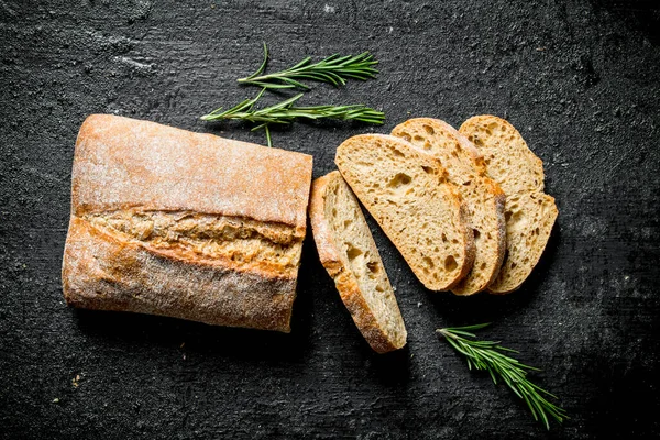 Biberiye Ile Dilimlenmiş Ciabatta Ekmek Siyah Rustik Arka Plan Üzerinde — Stok fotoğraf