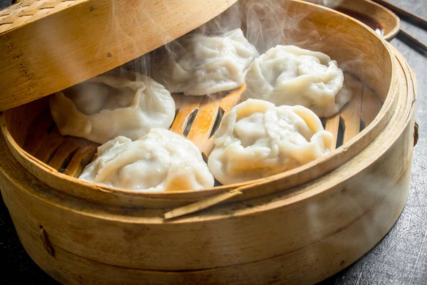 stock image Hot dumplings manta in a bamboo steamer. On rustic background