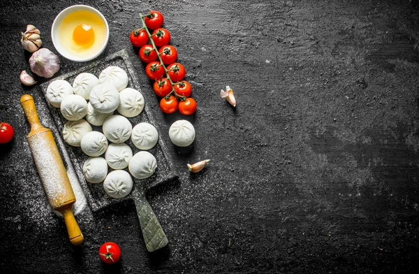 生曼塔饺子 大蒜和西红柿 在黑色质朴的背景 — 图库照片