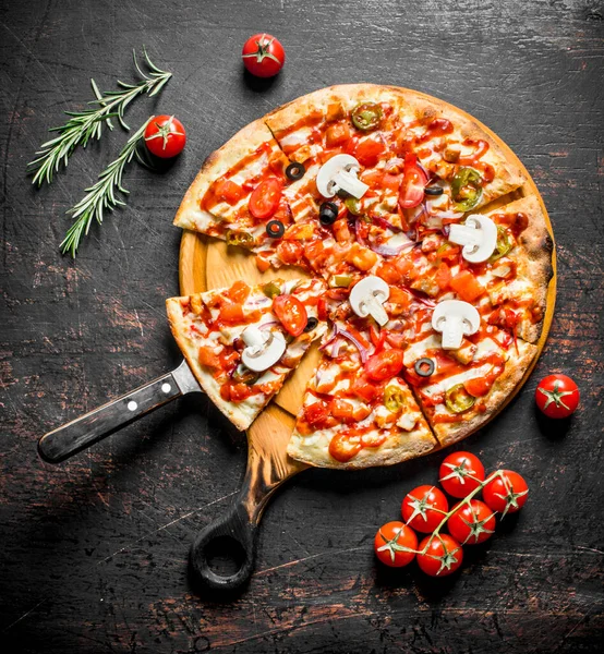 Kesme Tahtasında dilimlenmiş kokulu Meksika pizzası. Koyu rustik arka plan üzerinde